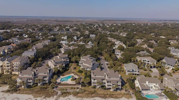 A coastal residential area with houses, a swimming pool, and a beach.