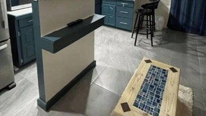 Una cucina moderna con TV integrata, mobili azzurri e un'area pranzo con uno sgabello da bar.
