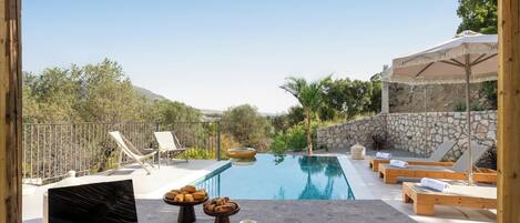 Relax by the serene pool surrounded by comfortable lounge chairs and a shaded seating area.
