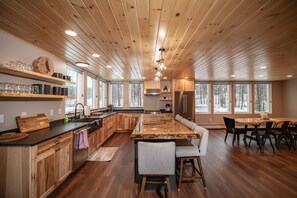 Une cuisine spacieuse avec des meubles en bois, un grand îlot central et un coin repas équipé de chaises.