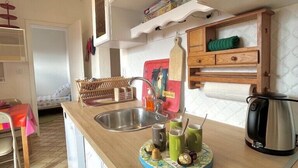 A kitchen with white cabinets, a wooden countertop, a sink, and a kettle. - Biarritz - Beaurivage - Proche côte des Basques (Biarritz)