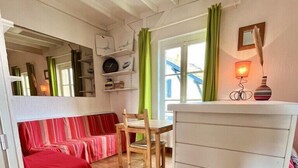 A cozy room with a bed, a desk, and a chair. There is a window with curtains, a lamp, and a mirror on the wall. - Biarritz - Beaurivage - Proche côte des Basques (Biarritz)