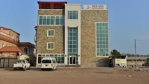 Un edificio de varios pisos con un letrero que dice 'RED SEA HOTEL APARTMENT'.