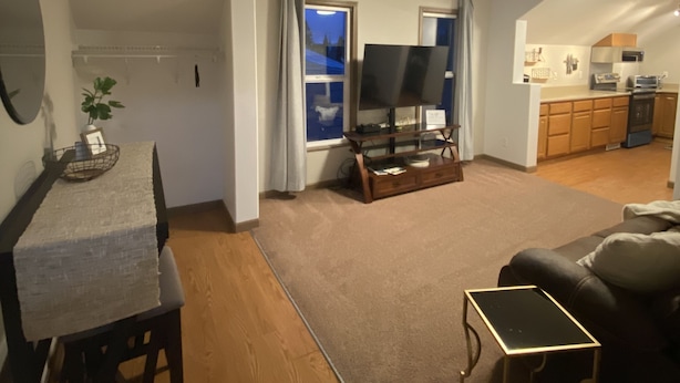 A spacious living area with a dining table, a sofa, and a TV. There is a kitchen in the background. - Chehalis upstairs 2 bd 2 bath apartment (Chehalis)