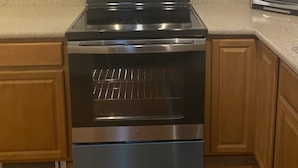 A kitchen with a stainless steel oven, microwave, and toaster. There are wooden cabinets and a granite countertop. - Chehalis upstairs 2 bd 2 bath apartment (Chehalis)