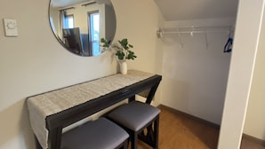 A small, cozy room with a round mirror, a small table with two chairs, a potted plant, and a coat rack. - Chehalis upstairs 2 bd 2 bath apartment (Chehalis)