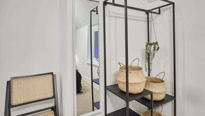 A room with a black metal shelf unit holding woven baskets and a hanging plant. - Host & Stay | High Street Cottage (Norton)