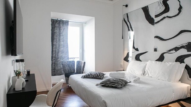 A modern bedroom with a large bed, a desk, and a chair. - Bhr Cavour 150 (Rome)