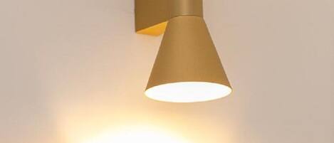 Een wandlamp met een kegelvormige lampenkap.