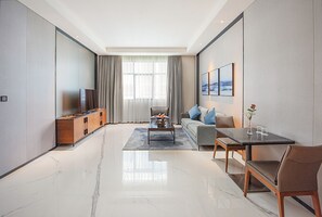 Executive tweepersoonskamer | Woonruimte | Een 49-inch televisie met satellietzenders en een printer