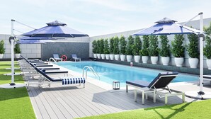 Et poolområde med liggestole, parasoller og plantekrukker.