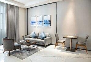 Executive tweepersoonskamer | Woonruimte | Een 49-inch televisie met satellietzenders en een printer