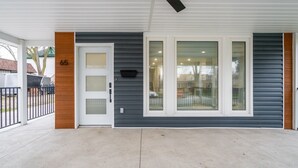 A house with a covered porch, a number '65' on the door, and a ceiling fan. - 65 on the Main in the heart of Kingsville (Kingsville)