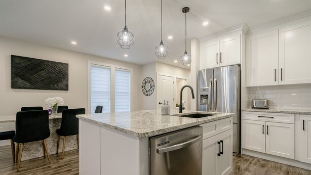 A modern kitchen with white cabinetry, stainless steel appliances, and a granite countertop. - 65 on the Main in the heart of Kingsville (Kingsville)
