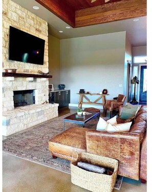 Cozy living area with a fireplace, flat-screen TV, and comfortable seating.