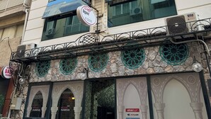 A multi-story building with large windows, air conditioning units, and a sign for 'Begovil Pansiyon'. - Begonvil Pansiyon Konaklama (Izmir)