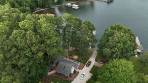 Vue aérienne d’un quartier résidentiel avec une maison, un quai et un lac.