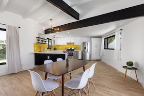 A modern kitchen with white cabinets, a yellow backsplash, and stainless steel appliances. - Private mini oasis steps from El Paseo! (Palm Desert)