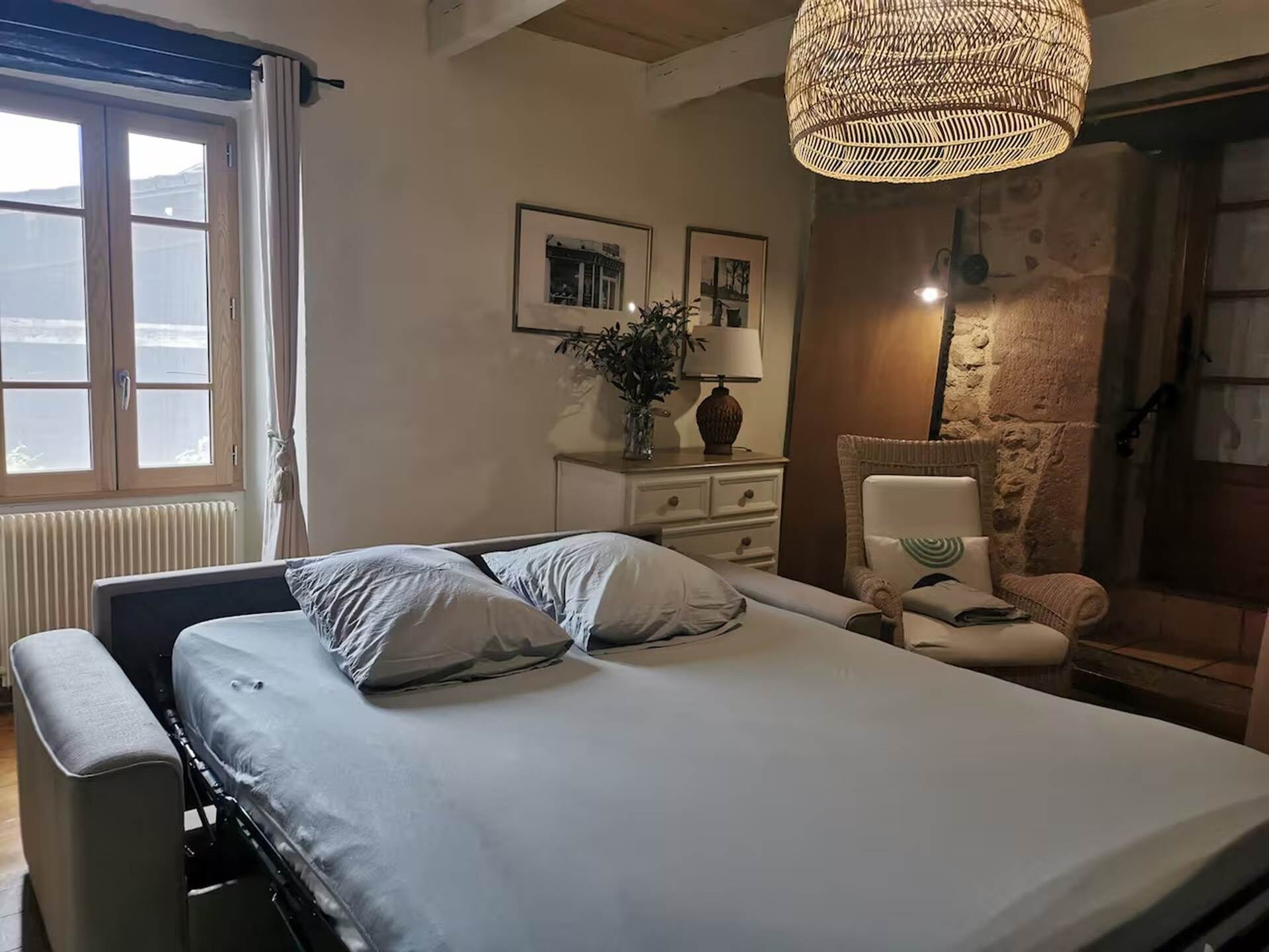 Une chambre à coucher avec un lit, une table de chevet, une lampe et une étagère fixée au mur.