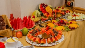 Una mesa con diversas frutas y un pastel, con etiquetas que identifican distintos tipos de comida.