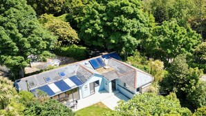 A modern house with a sloped roof, solar panels, and a large garden. - Trevint - Modern beach house in Falmouth, private parking (Falmouth)