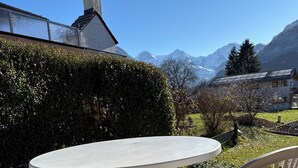 A round table with two white plastic chairs in an outdoor setting. - Traditional Chalet with views of the Eiger, Monch & Jungfrau! (Unterseen)