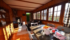 A cozy dining area with a wooden table, chairs, and a fireplace. - Traditional Chalet with views of the Eiger, Monch & Jungfrau! (Unterseen)