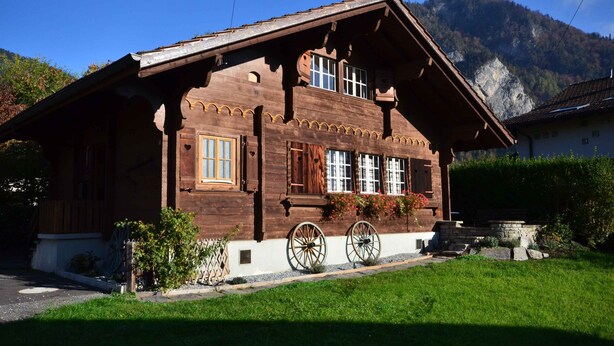 A traditional wooden chalet with a sloped roof, large windows, and a stone foundation. - Traditional Chalet with views of the Eiger, Monch & Jungfrau! (Unterseen)