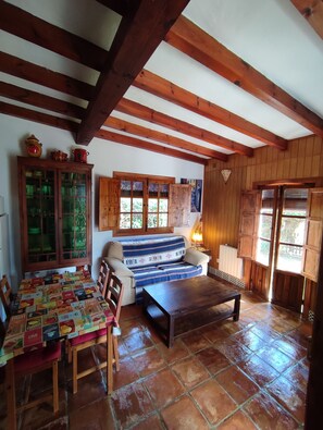 Une pièce chaleureuse avec un plafond en bois, un canapé, une table et un meuble.