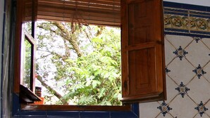 A kitchen with a window, wooden shutters, a sink, and a tiled backsplash. - Andalucía; Cádiz; Vejer de la Frontera;  cottage  Finca la Hijuela, casa Encina (Vejer de la Frontera)