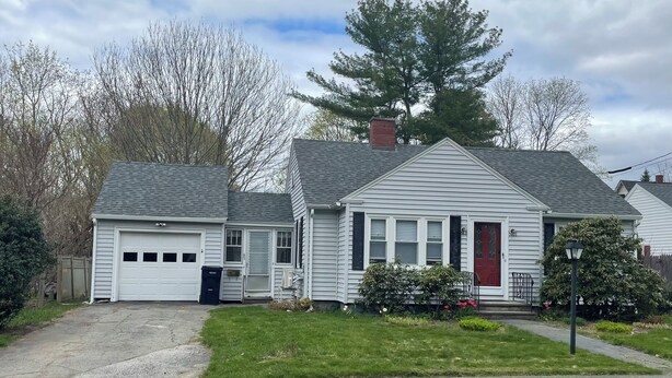 A two-story house with a garage, a front porch, and a well-maintained lawn. - Quiet single-level fully furnished house (Bangor)