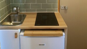 A compact kitchen with a microwave, sink, and a built-in dishwasher. - Studio 2-3 pers. at the foot of the slopes (Mâcot-la-Plagne)