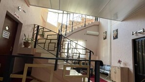 A staircase with a geometric design, a red carpet, and a sign indicating a kitchen area.