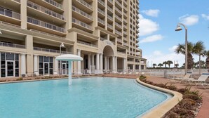 A hotel with a large pool, multiple balconies, and a clear sky. - Gorgeous Ocean and Bayside View (Miramar Beach)