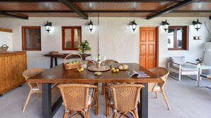 A dining area with a wooden table, wicker chairs, and a buffet setup.