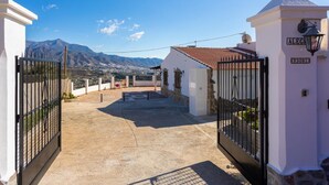 Una entrada tancada amb tanca a una propietat, amb una vista de muntanya al fons.