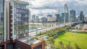 Un bâtiment moderne doté de grandes fenêtres et d’une pelouse verdoyante à l’avant.