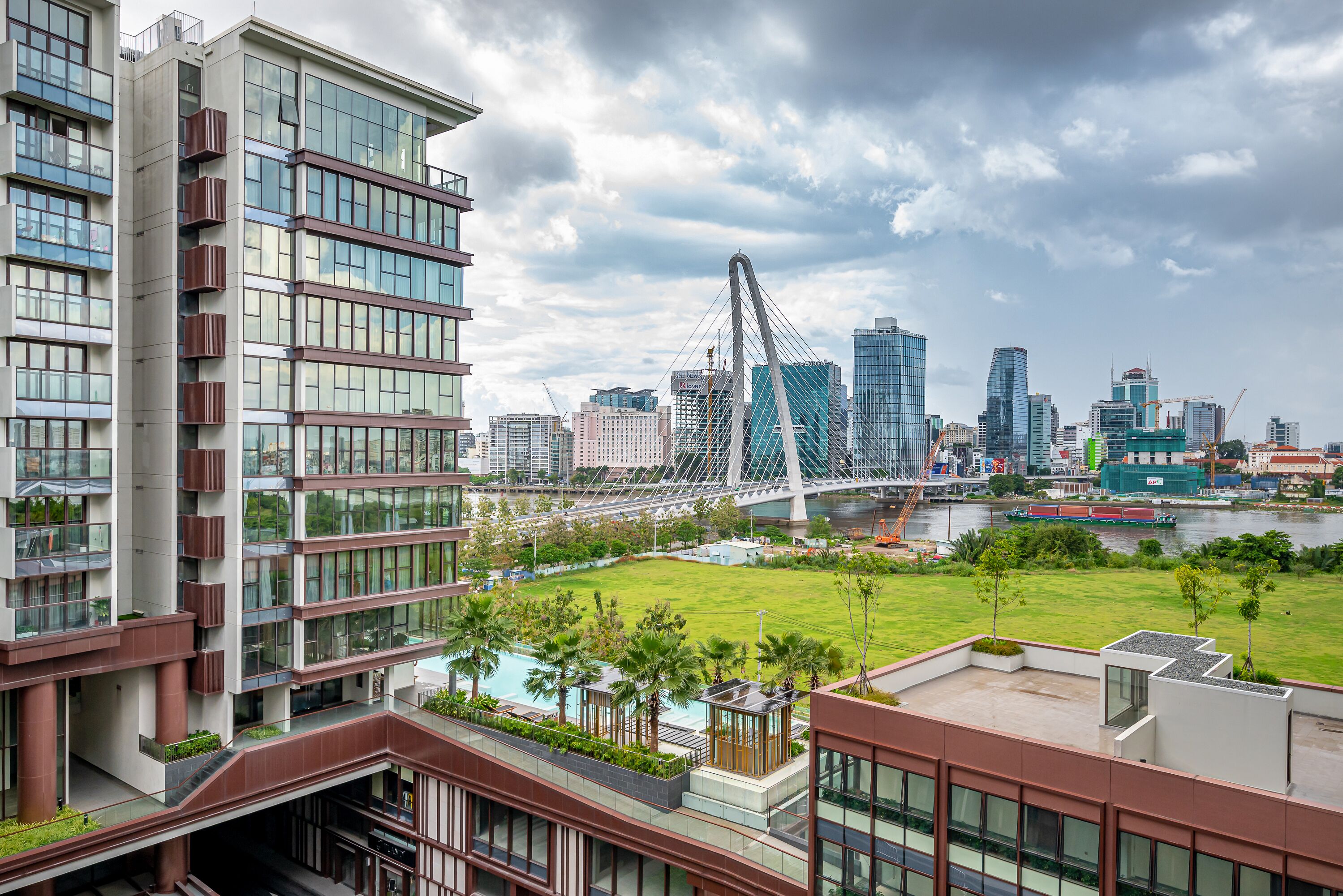 A modern building with multiple floors, large windows, and a rooftop garden.
