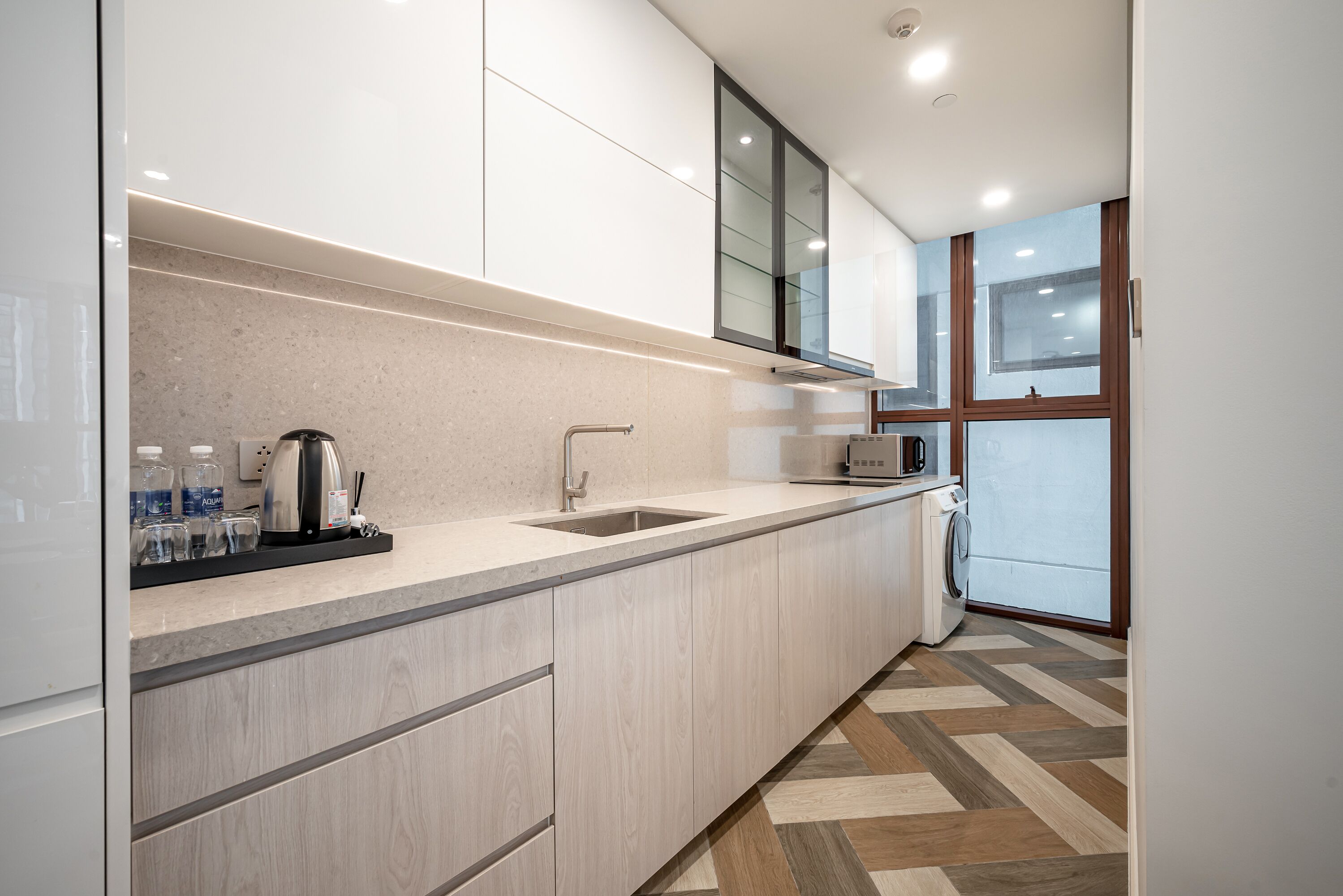 A modern kitchen with a built-in sink, a microwave, and a coffee maker.