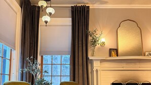Un salon chaleureux avec deux fauteuils, une cheminée et un tapis à motifs.