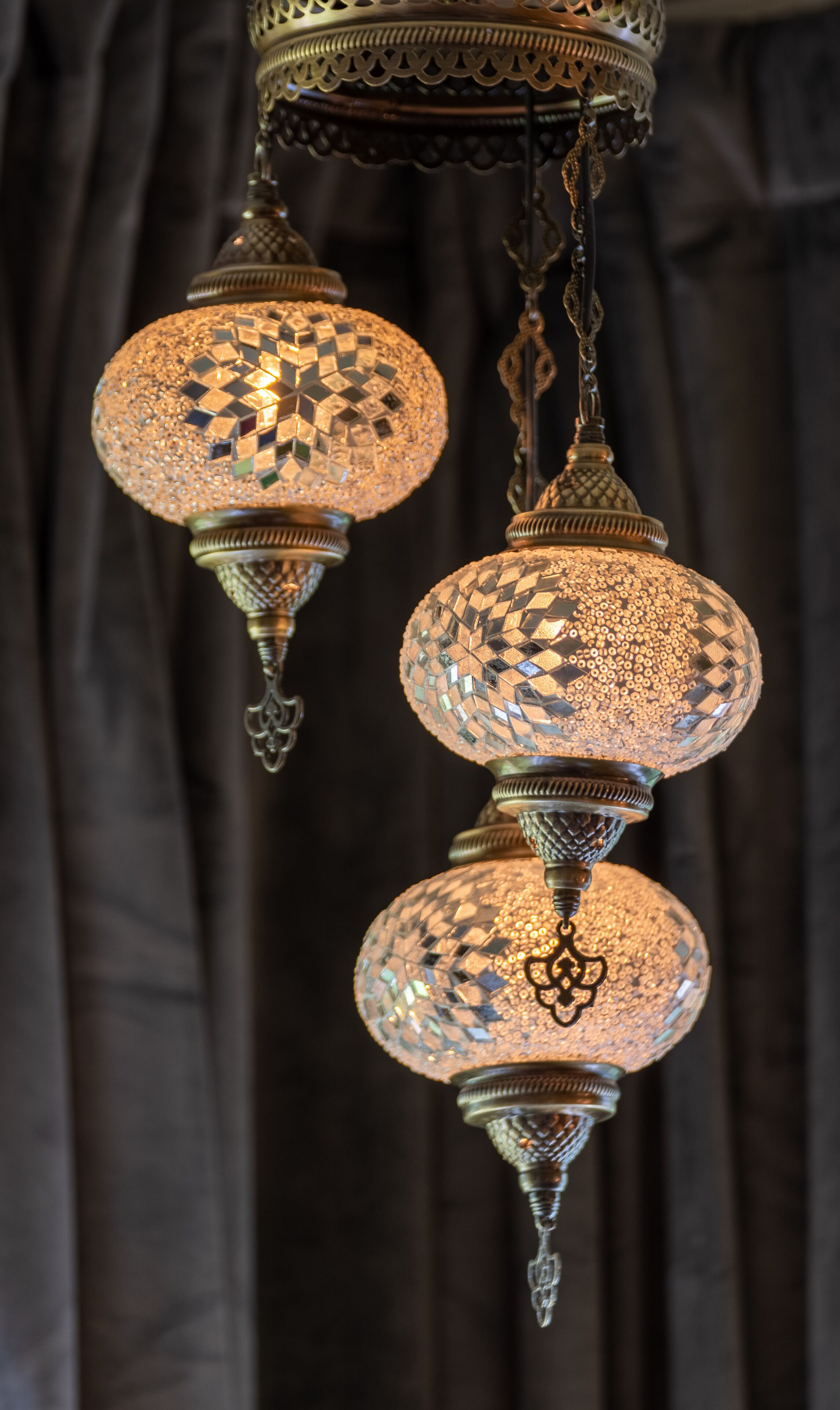 A chandelier with intricate metalwork and multiple spherical glass shades.