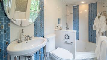 A bathroom with a white sink, toilet, and shower.