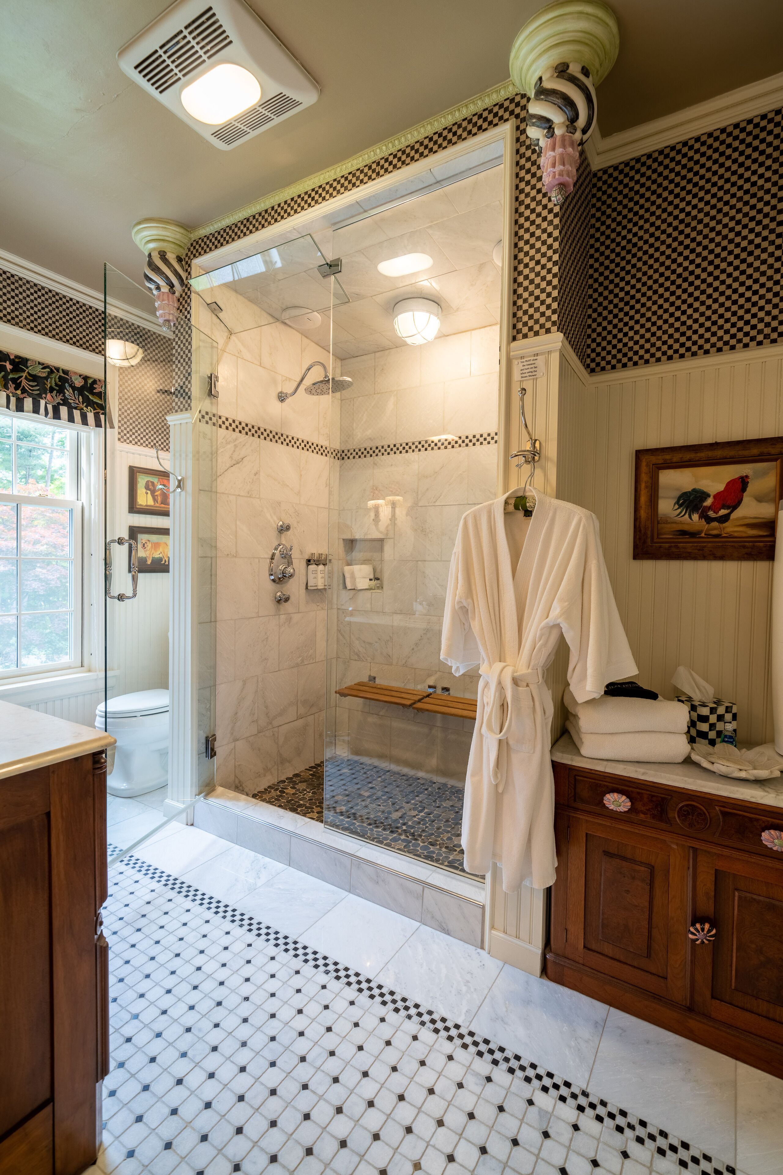 A bathroom with a glass-enclosed shower, a white bathtub, and a wooden vanity with a mirror.