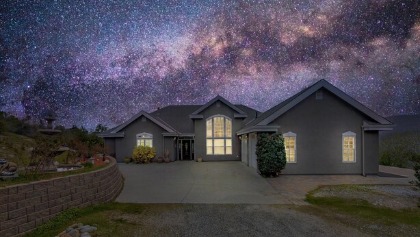 Une maison avec une allée et un ciel étoilé.