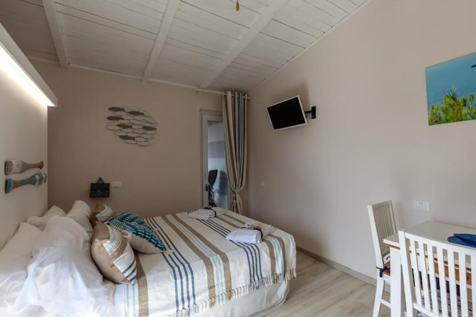 Un dormitorio con cama, escritorio y televisor.