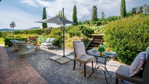 An outdoor patio with wicker furniture, a table with plates and a glass, and a pergola providing shade. - Donato one bedroom Farmhouse Apartment with shared Pool in Fattoria Sardi Wine Resort in Lucca (Monte San quirico)