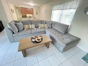 Relax in this stylish living room with a comfortable sofa, coffee table, and kitchen area.