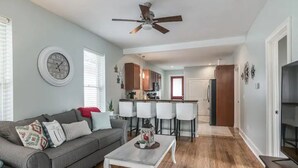 A living room with a grey sofa, a coffee table, and a ceiling fan. - Chestnut Street Charmer-Walk to Louisville! (Jeffersonville)