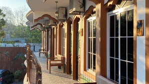 A covered outdoor seating area with benches, a stone-tiled floor, and a view of the street. - Hotel y Restaurante Las Adas y Estrellas (Melchor de Mencos)