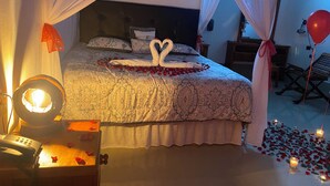 A bedroom with a bed, a bedside table with a lamp, and a canopy. - Hotel y Restaurante Las Adas y Estrellas (Melchor de Mencos)